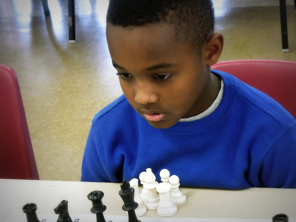 Little kid concentrating on playing chess